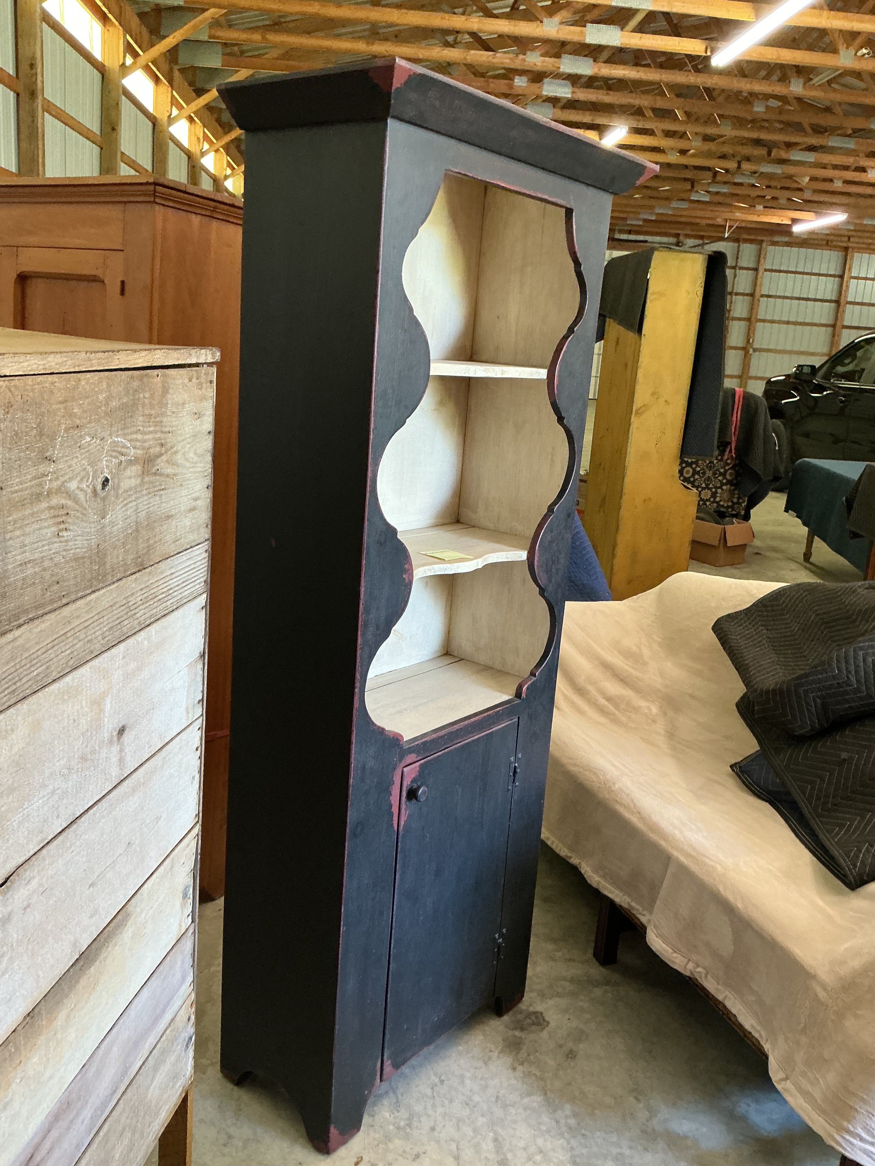 Scalloped wall cupboard in black over red