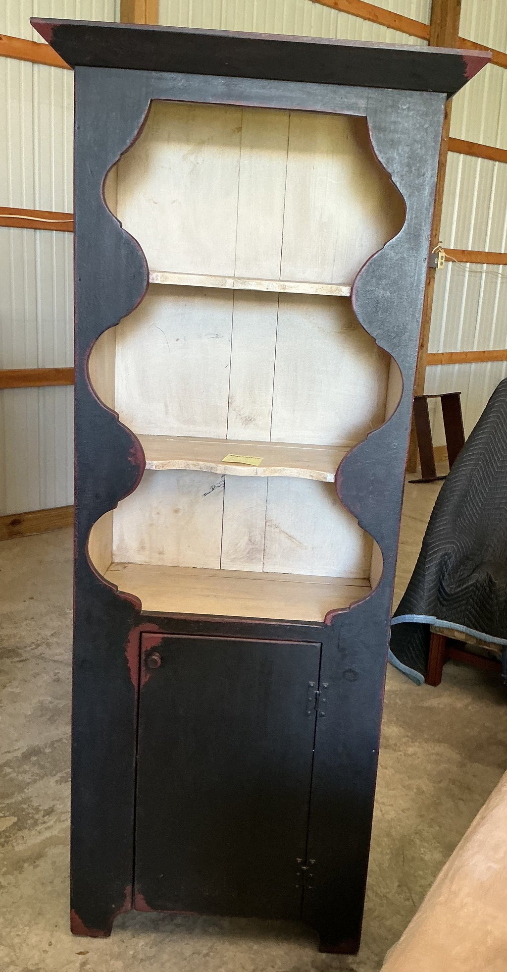 Scalloped wall cupboard in black over red