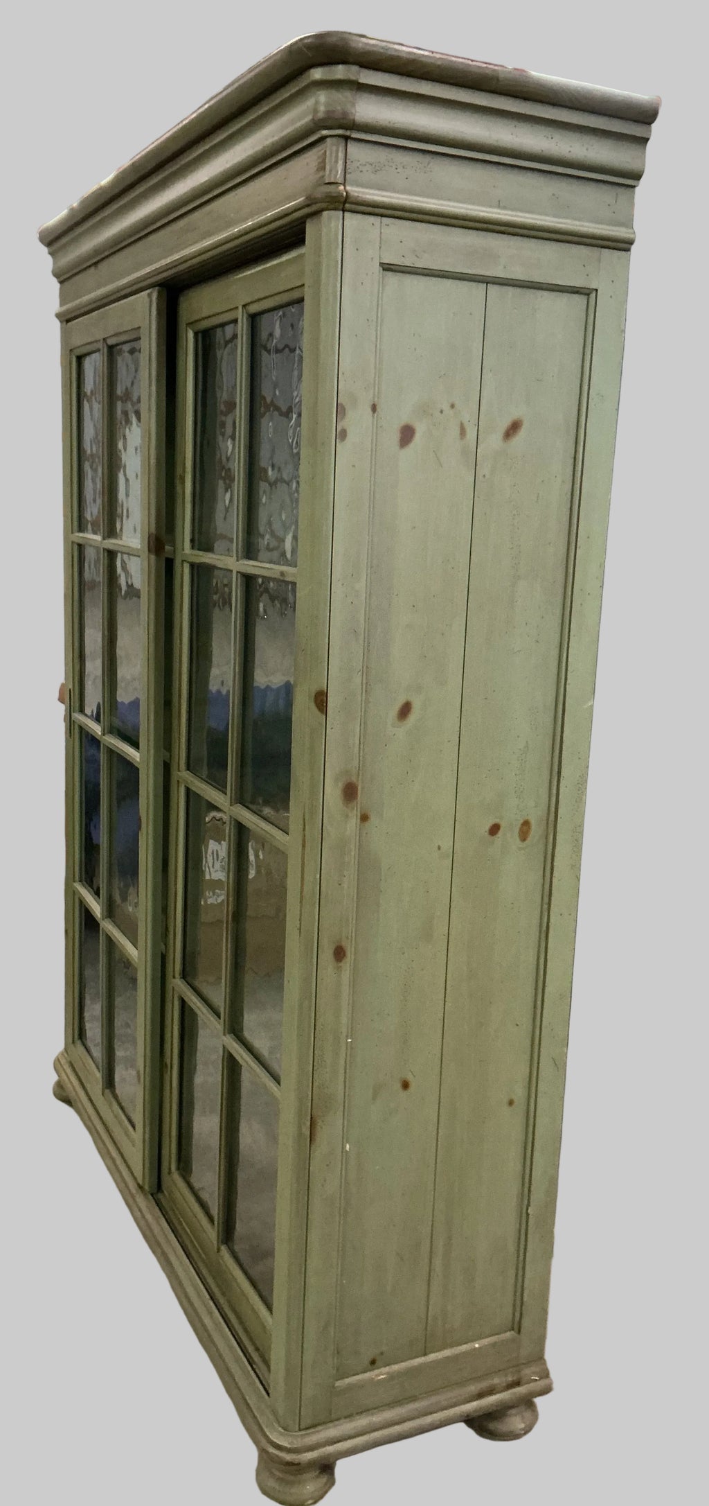 Green bookcase/display cupboard with 2 sliding doors.